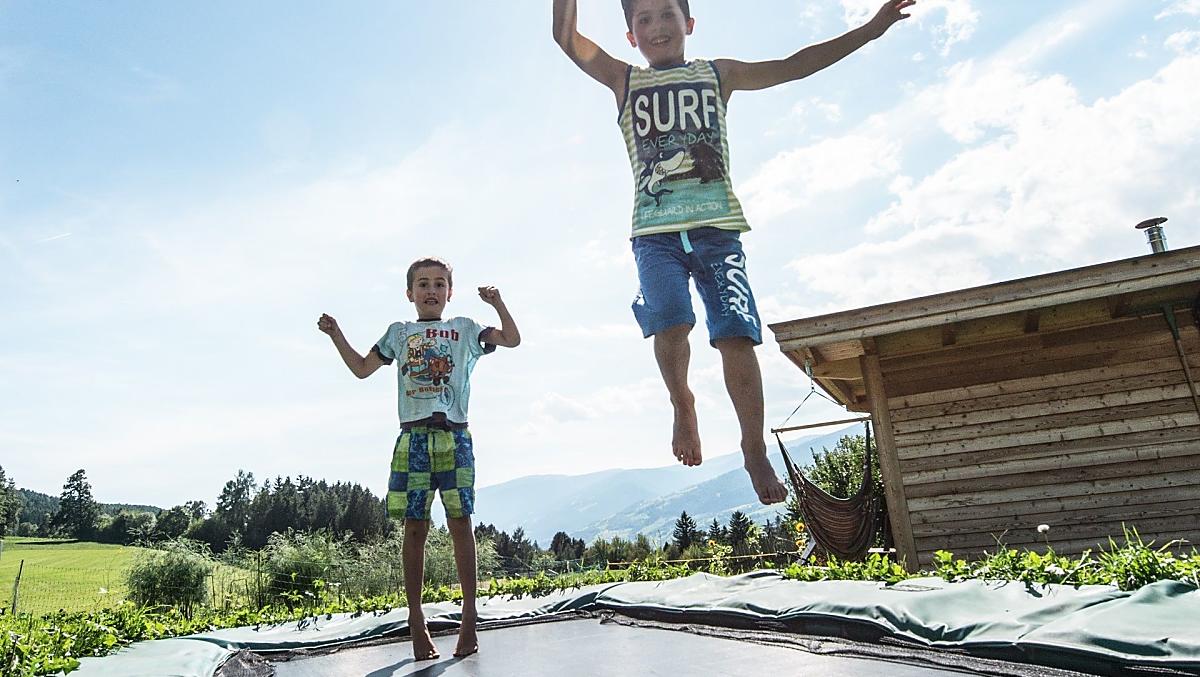 Divertimento per i bambini: saltare sul tappeto elastico