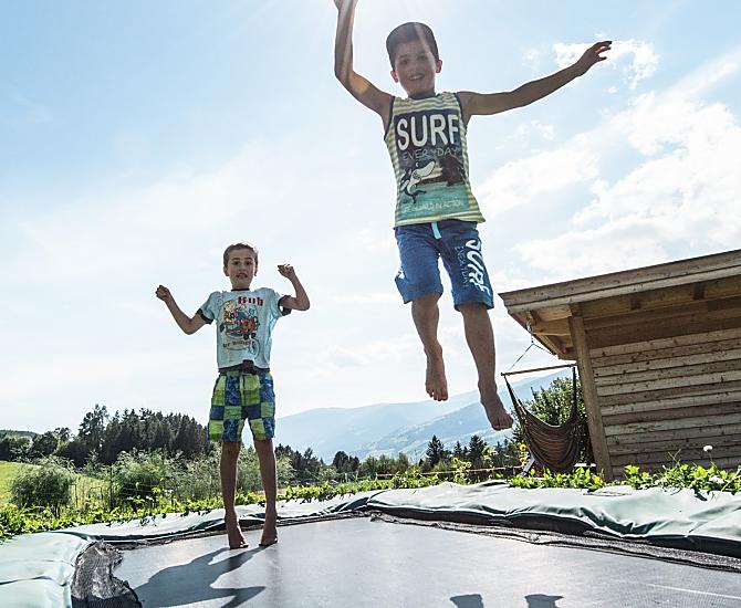 Divertimento per i bambini: saltare sul tappeto elastico