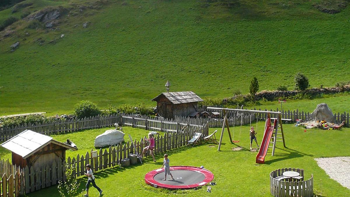 Parco giochi naturale con molte possibilità di divertimento: sabbiera, giostra, trampolino, altalena, scivolo, corda per arrampicarsi, trattori a pedali, trampoli, ecc.