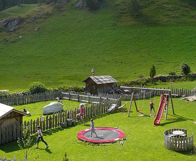 Parco giochi naturale con molte possibilità di divertimento: sabbiera, giostra, trampolino, altalena, scivolo, corda per arrampicarsi, trattori a pedali, trampoli, ecc.