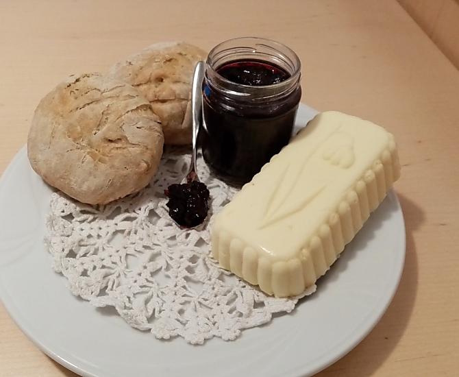 Per una colazione deliziosa: pane fatto in casa con burro fresco del contadino e deliziosa marmellata di mirtilli.