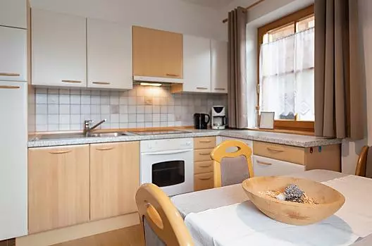 Vi attende una cucina funzionale con bollitore, piano cottura in vetroceramica, frigorifero e freezer, macchina del caffè e forno.