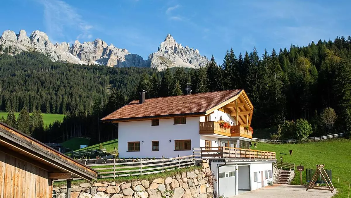 La casa contadina con il Latemar sullo sfondo.