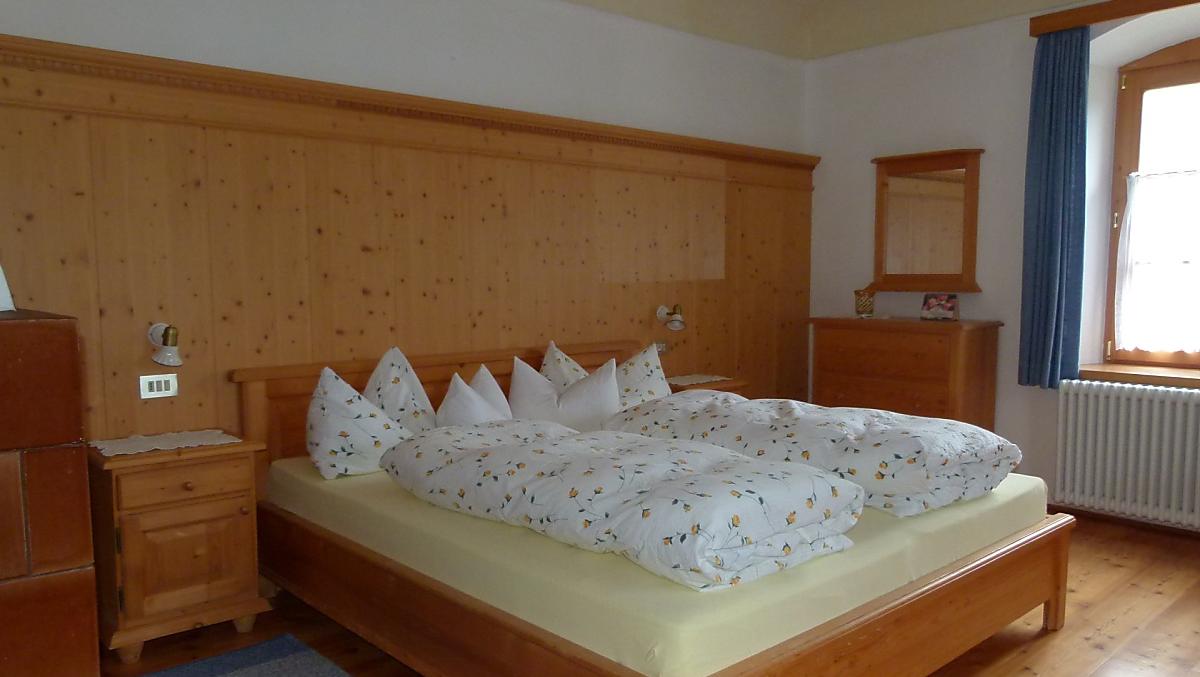 L'ampia camera da letto dell'appartamento vacanze Abendsonne: pavimenti in legno e mobili in legno massiccio garantiscono il benessere