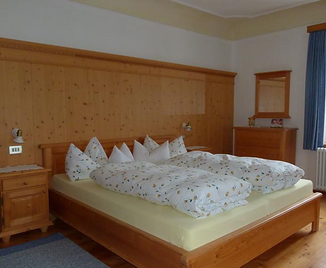 L'ampia camera da letto dell'appartamento vacanze Abendsonne: pavimenti in legno e mobili in legno massiccio garantiscono il benessere