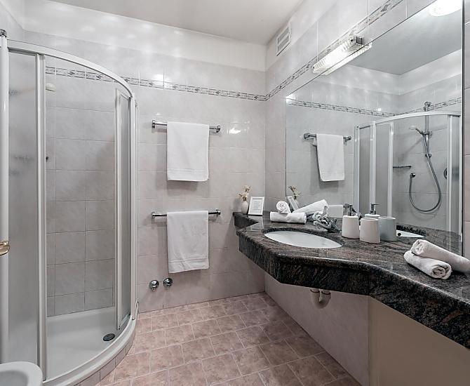 Ein klassisches Badezimmer mit Dusche, Bidet/WC und Waschbecken mit großer Ablagefläche aus echtem Marmorstein