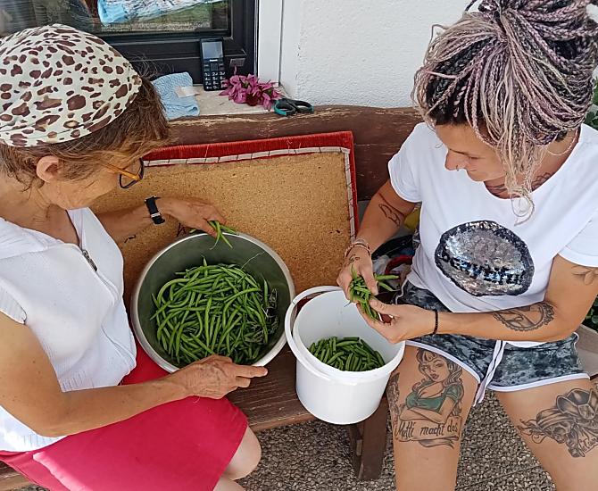 Nonna Cilli e la contadina Eva mentre puliscono i fagioli