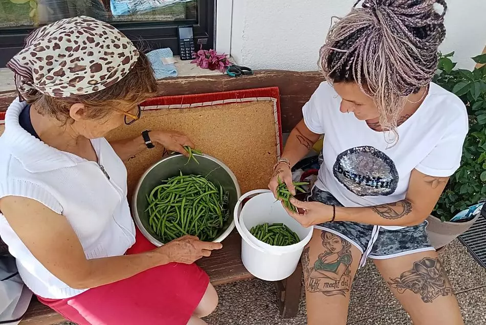 Nonna Cilli e la contadina Eva mentre puliscono i fagioli