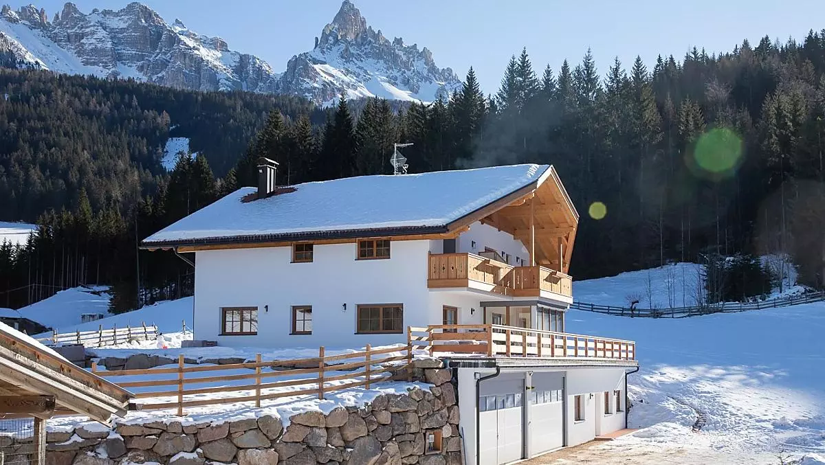 Il maso in inverno, con il Latemar sullo sfondo.