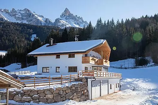 Il maso in inverno, con il Latemar sullo sfondo.
