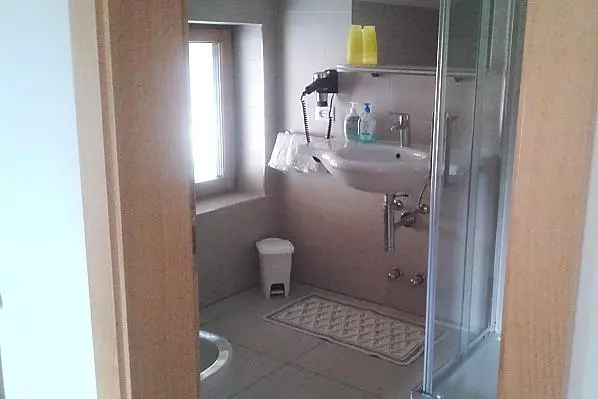 Bad mit Dusche und Duschkabine, Waschbecken, WC und Bidet.