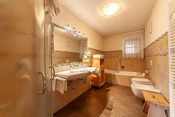 Dusche und Badewanne, zwei Waschbecken und ein Bidet