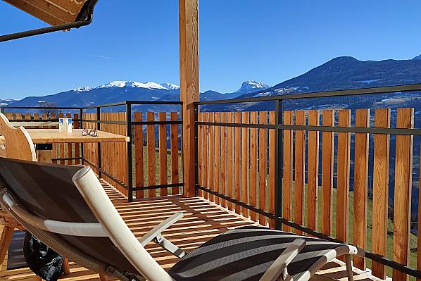 Herrliche Aussicht zu den Dolomiten auf dem großen, überdachten Balkon mit Tisch und Liegestuhl.