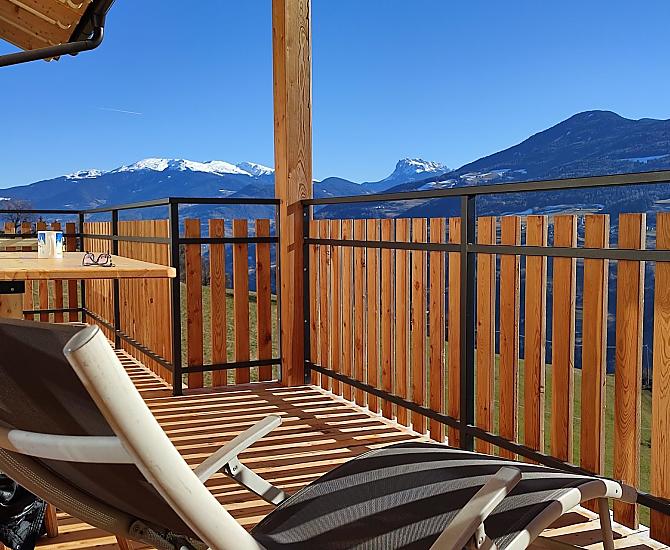 Herrliche Aussicht zu den Dolomiten auf dem großen, überdachten Balkon mit Tisch und Liegestuhl.