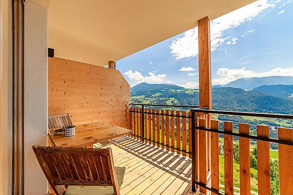 Herrliche Aussicht auf die Dolomiten auf dem großen, überdachten Balkon mit Tisch und Liegestuhl.