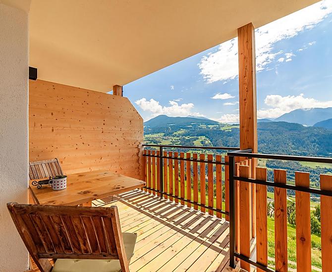 Herrliche Aussicht auf die Dolomiten auf dem großen, überdachten Balkon mit Tisch und Liegestuhl.