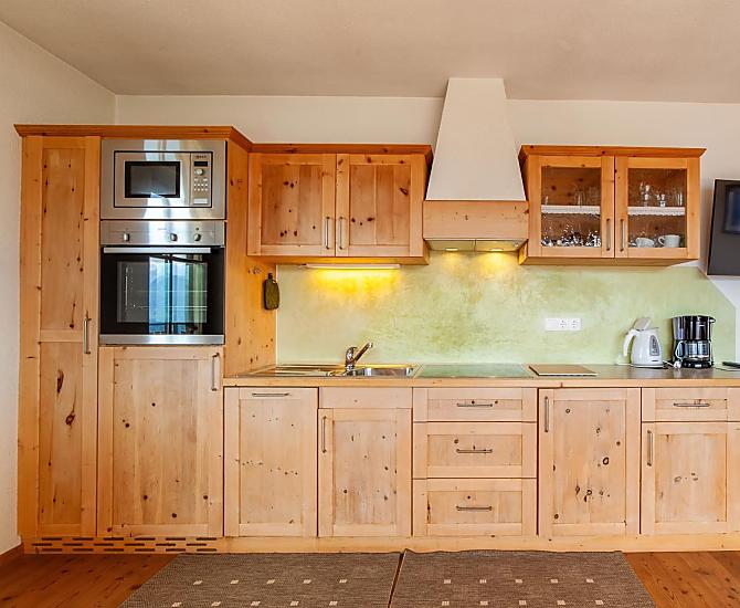 Küchenzeile mit Mikro, Backofen, Kühlschrank mit Gefrierfach, Spülmaschine und Elektrokochfeld.