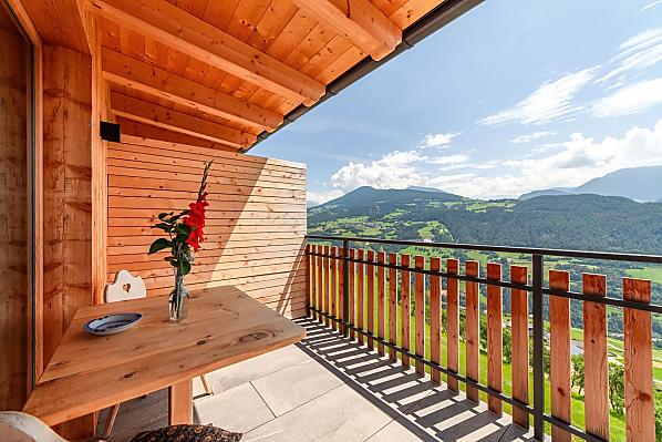 Herrliche Aussicht zu den Dolomiten auf dem großen, überdachten Balkon mit Tisch und Liegestuhl.