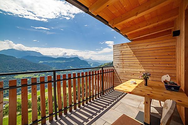 Herrliche Aussicht zu den Dolomiten auf dem großen, überdachten Balkon mit Tisch und Liegestuhl.