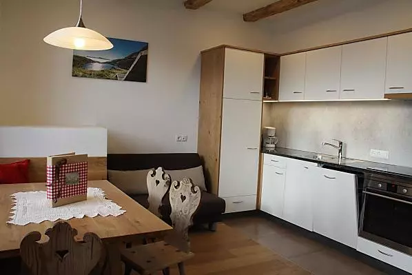 Küche mit Backrohr, Kühlschrank, Kaffeemaschine, Ceranfeld, Spülmaschine und Wasserkocher