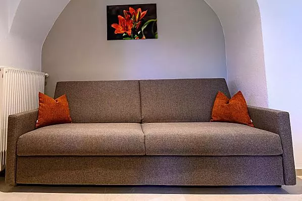 Die gemütliche Couch gegenüber der Küche lädt zum Verweilen ein.