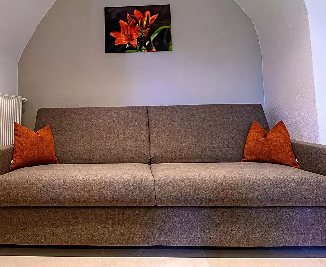 Die gemütliche Couch gegenüber der Küche lädt zum Verweilen ein.