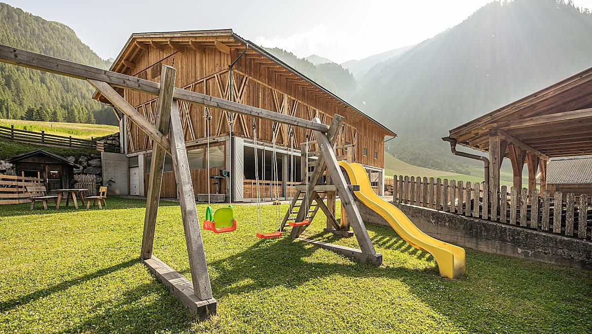 Parco giochi naturale con tante possibilità di divertimento: sabbiera, altalena, scivolo e ampio prato per giocare.