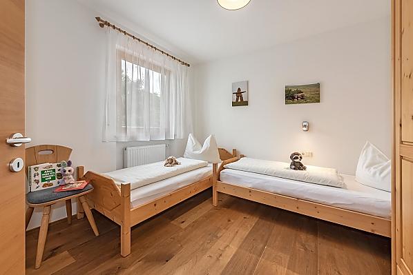 Kinderzimmer mit zwei vollwertigen Betten.