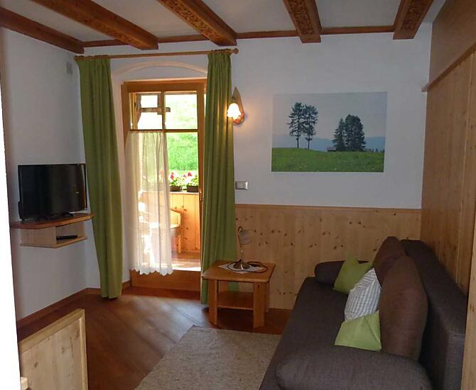 Wohnzimmer mit ausziehbarer Couch und Sitzecke
