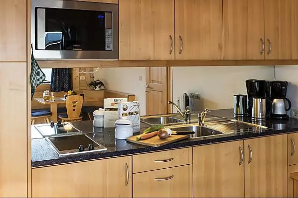 Küche mit Kühlschrank, Spülmaschine, Kaffeemaschine und Mikrowelle.