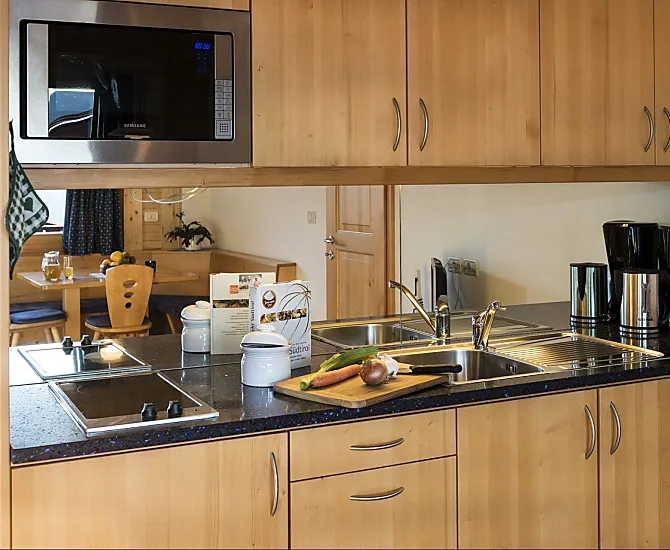 Küche mit Kühlschrank, Spülmaschine, Kaffeemaschine und Mikrowelle.