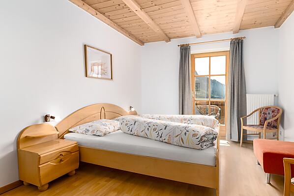 Helles, großes Schlafzimmer mit Doppelbett und Zugang zum Balkon mit herrlichem Weitblick.