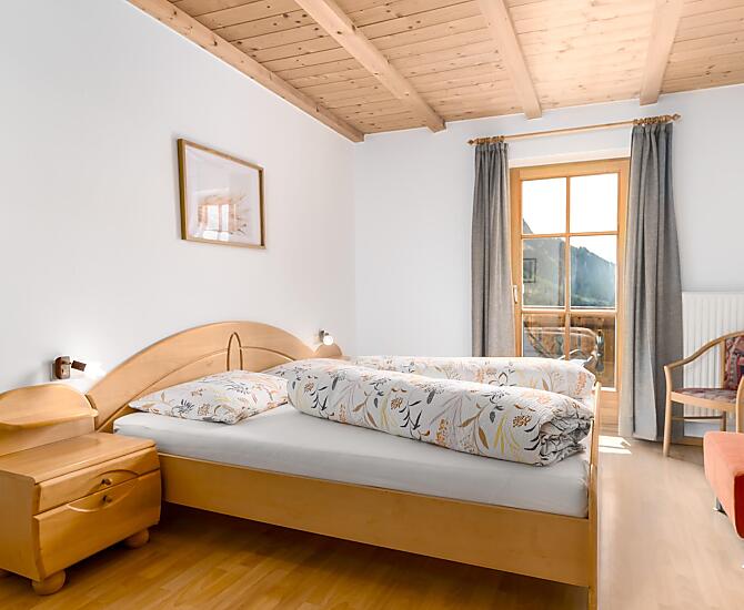 Helles, großes Schlafzimmer mit Doppelbett und Zugang zum Balkon mit herrlichem Weitblick.