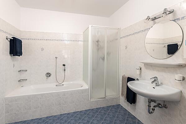 Großes Bad mit Badewanne, Dusche, Bidet und WC.