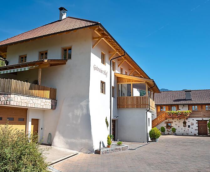 Casa principale ed ex stalla delle mucche, dove oggi si trova l’appartamento vacanze Traube.