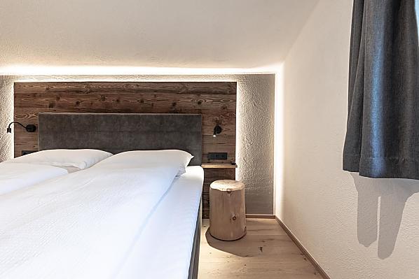 Schlafzimmer mit Holzboden und Akzenten aus Altholz.