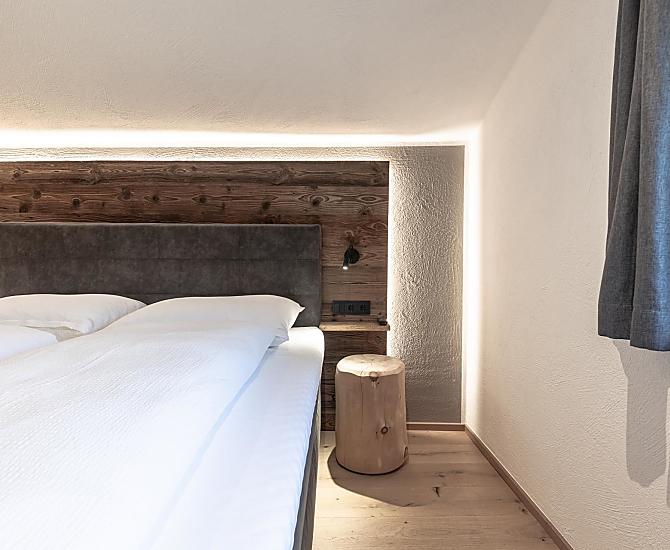 Schlafzimmer mit Holzboden und Akzenten aus Altholz.