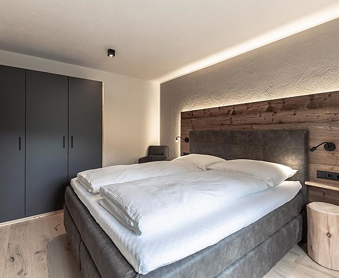 Schlafzimmer mit Holzboden und Akzenten aus Altholz.