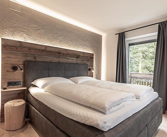 Schlafzimmer mit Holzboden und Akzenten aus Altholz.