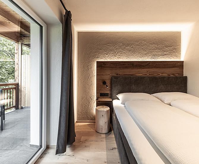 Schlafzimmer mit Holzboden und Akzenten aus Altholz.