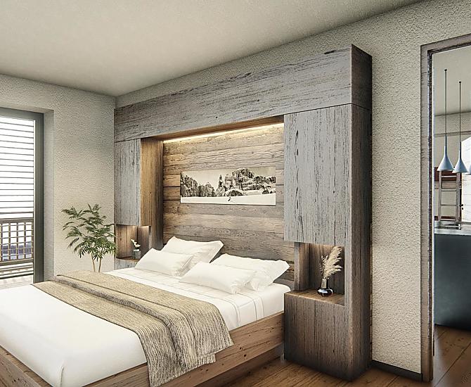 Schlafzimmer mit Holzboden und Einrichtung aus Altholz.