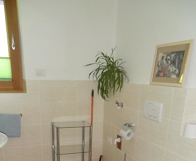 Heimeliges Badezimmer mit viel Freiraum, Bodenheizung, WC, Bidet, Waschbecken, Dusche und Ausblick in die freie Natur. 