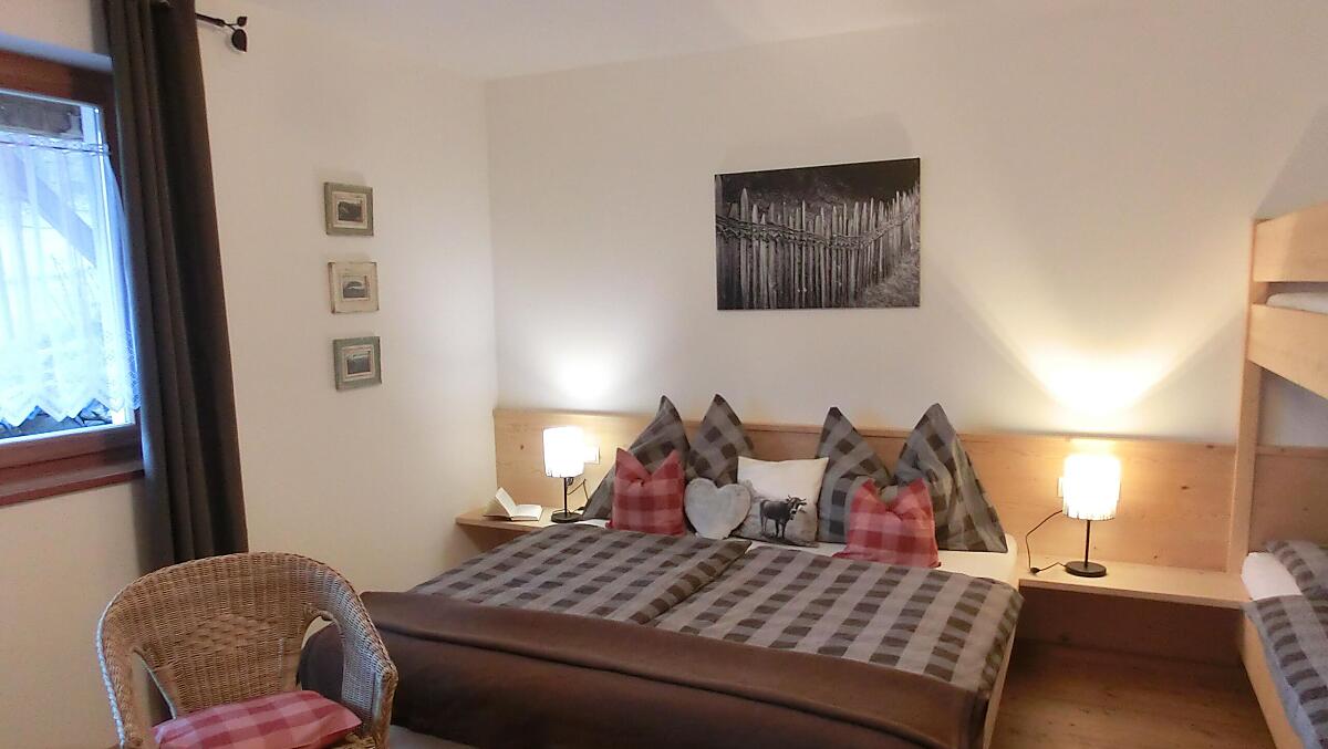 Schlafzimmer mit Doppelbett und Stockbett