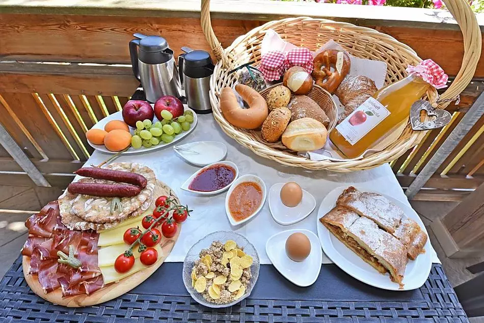 Colazione con marmellate e succhi di frutta fatti in casa, strudel di mele, Speck e formaggio nostrano
