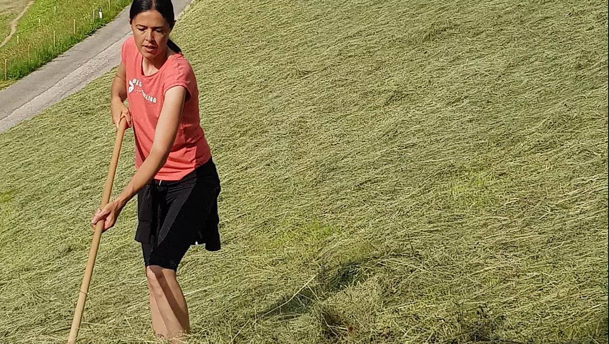 Andrea, la padrone di casa, porta il fieno in punti difficili da raggiungere e ripidi.