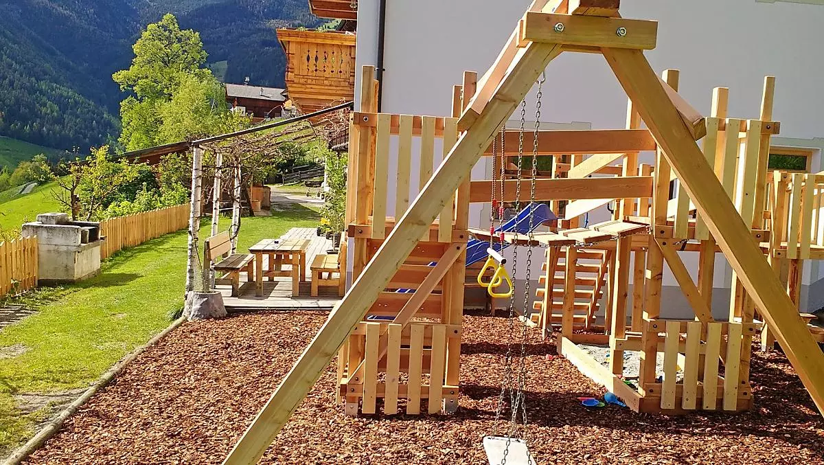 Il parco giochi, sullo sfondo il gazebo in giardino e il grill.