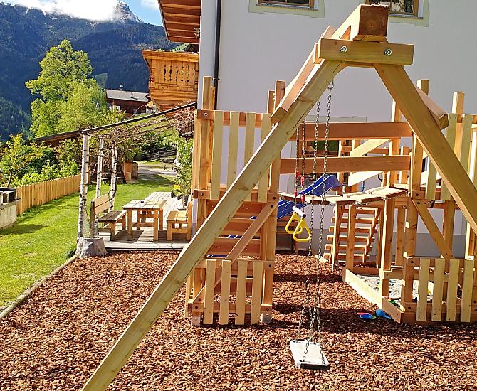 Il parco giochi, sullo sfondo il gazebo in giardino e il grill.