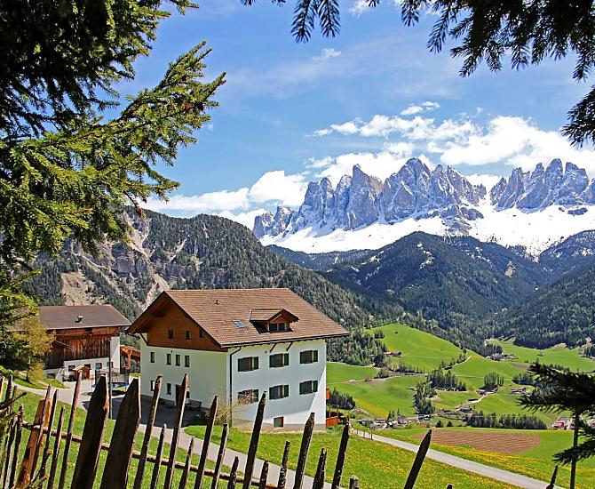 Vista del maso in primavera con la neve sul gruppo delle Odle