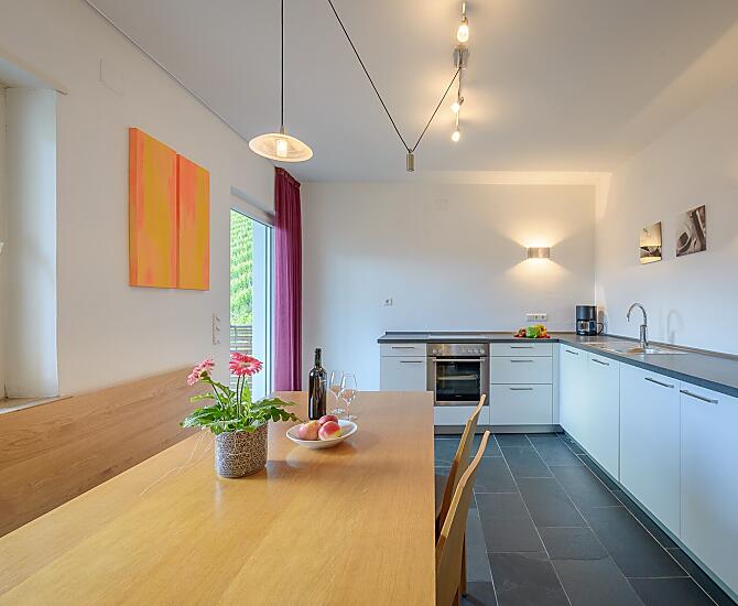 Viel Platz für euren Familien- oder Freundesurlaub - helle Küche mit Südbalkon und angrenzendem Wohnzimmer mit Couch und TV