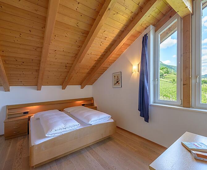 Schlafzimmer mit herrlichem Ausblick auf Tramin, den Poolbereich, in die Weinberge, in die Berge bis zur Sarner Scharte und aufs Weisshorn